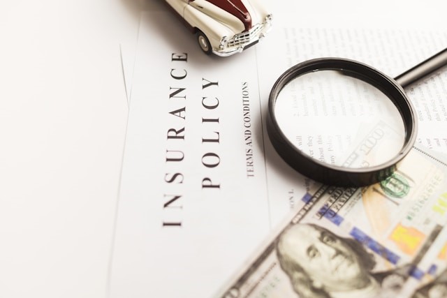 Magnifying glass, a car toy, and dollars on documents